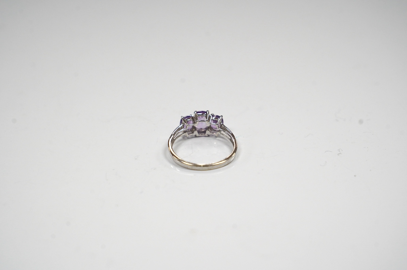 A modern 9ct gold and graduated three stone amethyst set dress ring, size O, gross weight 2.1 grams. Condition - fair to good